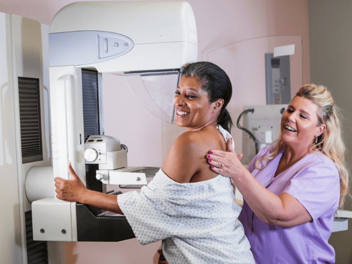 Woman smiling while undergoing a Mammography Screening